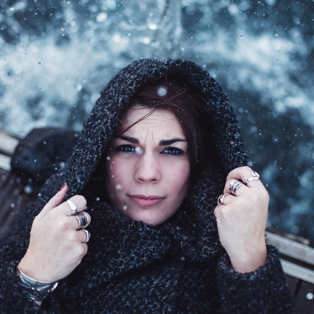 Frau mit Kapuze im Schneefall