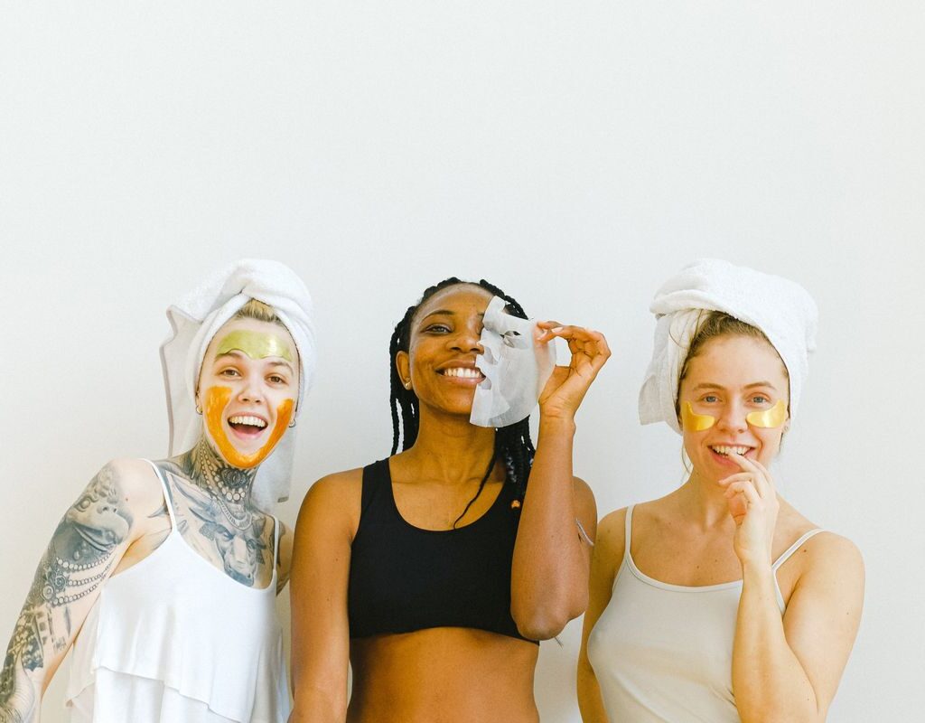 Drei Frauen mit Gesichtsmasken bei einer Hautpflege-Anwendung
