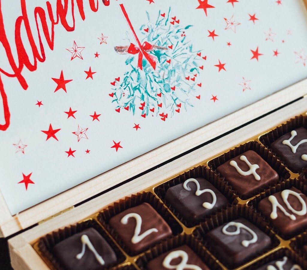 Geöffnete Holzschachtel mit nummerierten Schokoladenstücken als Adventskalender