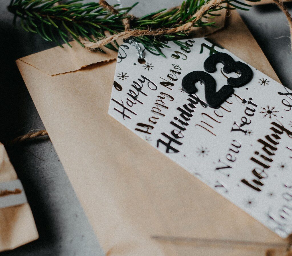 Geschenktüten aus Packpapier mit Tannenzweig und Zahlenanhänger wie bei einem Adventskalender